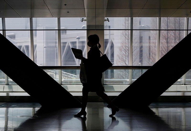 A female job seeker walks as she attends a job fair held for fresh graduates in Tokyo March 20, 2016.