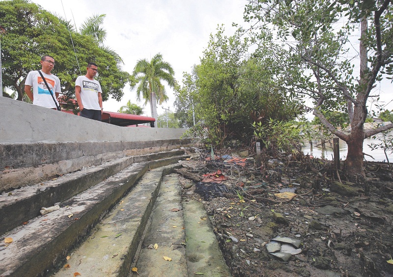 Chian (left) and Ong Jing Yan, 35, look at the barrier after it was completed last week. u00e2u20acu201d Picture by Marcus Pheong