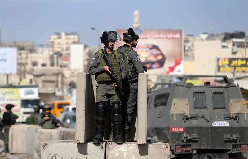 Israeli border policemen stand guard near the scene where Israeli police said a Palestinian was shot and killed by an Israeli security guard after the Palestinian tried to stab him, at Qalandiya checkpoint near the West Bank city of Ramallah November 22, 