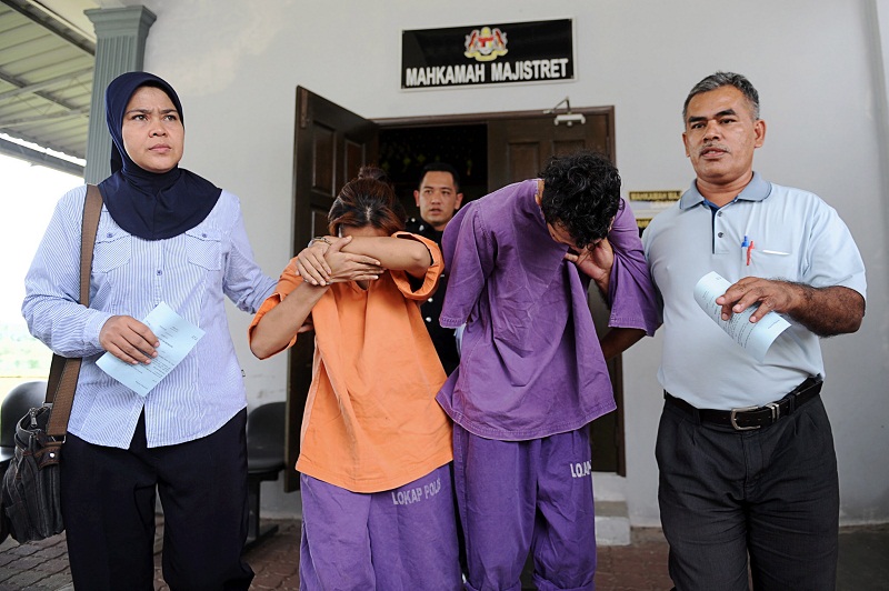 Police officers lead the two suspects involved in the Paya Nahu Flats abuse case into the Sungai Petani Magistrate Court November 24, 2016. u00e2u20acu201d Bernama pic