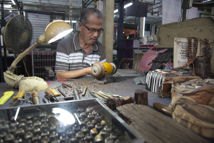 Ghazali Abdul Hamid fashions ‘stones’ from wood core to be mounted on rings. 