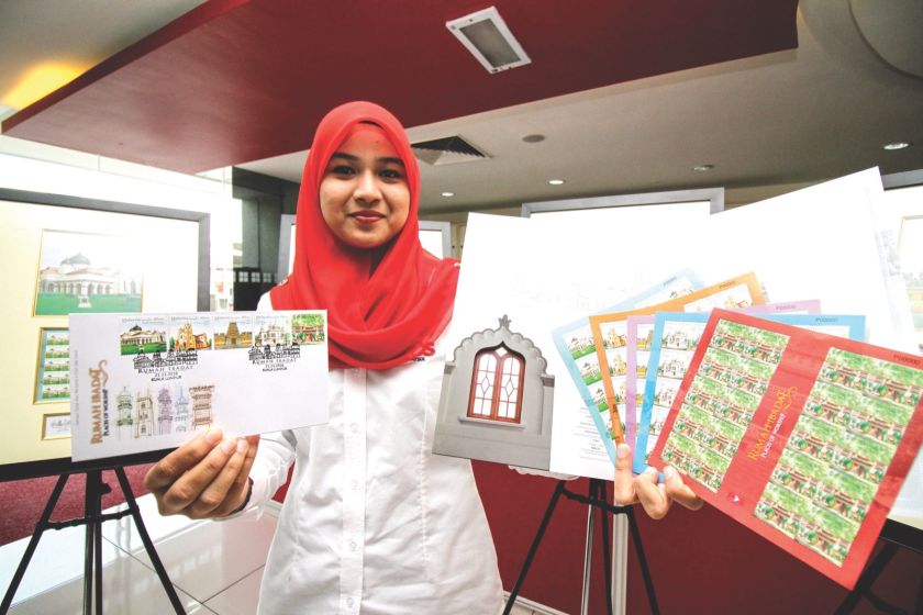 Nurul Inani Ismail, 25, holding the u00e2u20acu02dcPlaces of Worship Stamps Collectionu00e2u20acu2122 in Pos Malaysia Headquarters, Kuala Lumpur yesterday. u00e2u20acu201d Picture by Hari Anggara