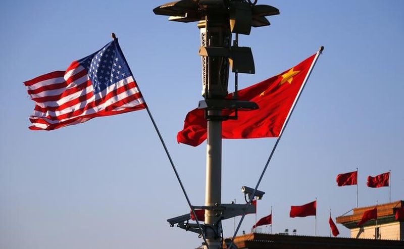 US (left) and Chinese national flags flutter on a light post at the Tiananmen Square ahead of a welcoming ceremony for US President Barack Obama, in Beijing, November 12, 2014. u00e2u20acu201d Reuters pic