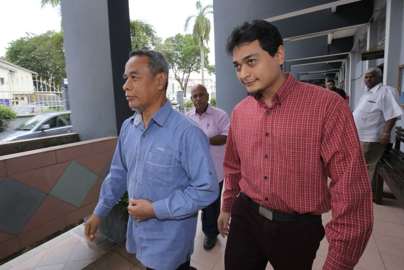Fathi Munzir Nadzri (right) and his father Datuk Nadzri Ismail leave the Ipoh sessions court after the former was acquitted of two charges related to the desecration of several idols at Ipoh's Sree Muneeswaran Aman Temple in April. u00e2u20acu2022 Picture by Marcus P