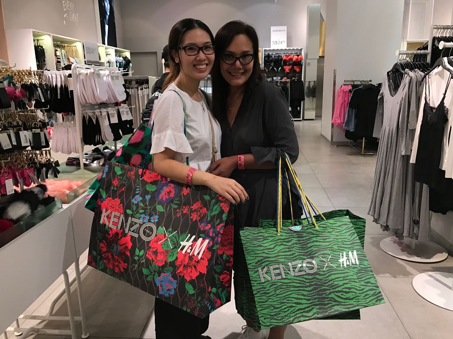 Maria Jessica (left) and Sherry Kuhara with their bags of purchases from Kenzo x H&M collection. u00e2u20acu201d Picture courtesy of Sonia Yeo