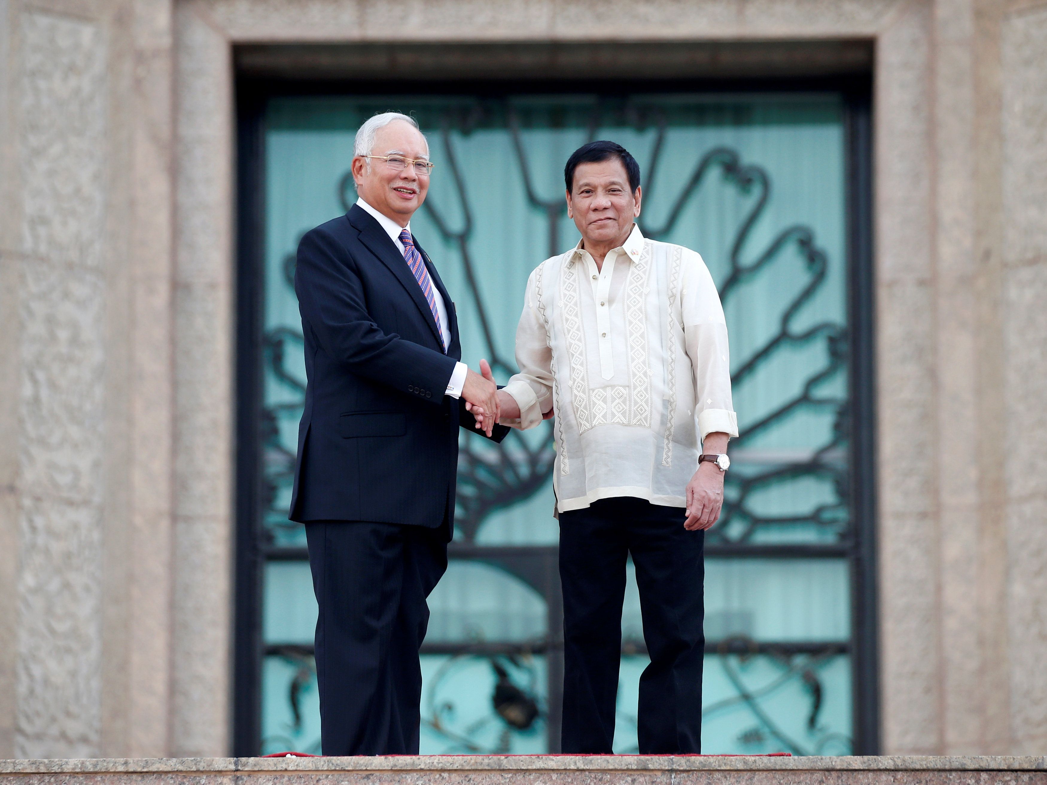 Philippines President Rodrigo Duterte and Prime Minister Datuk Seri Najib Razak (left) shake hands after a welcome ceremony in Putrajaya, November 10, 2016. u00e2u20acu2022 Reuters pic