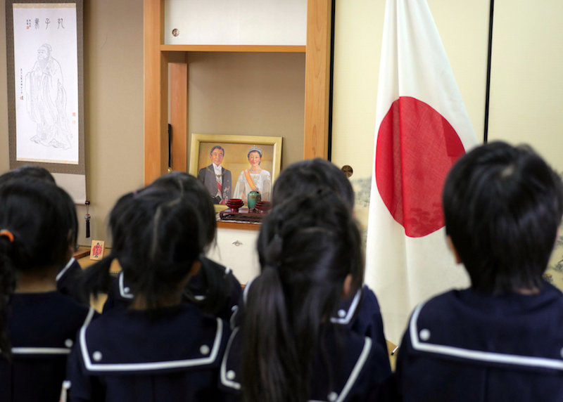 Students recite the Imperial Rescript on Education and Confucian Analects in front of Japan’s national flag, a picture of Japanese Emperor Akihito and Empress Michiko, and a hanging scroll of Confucius at Tsukamoto kindergarten in Osaka November 30, 2016. — Reuters pic