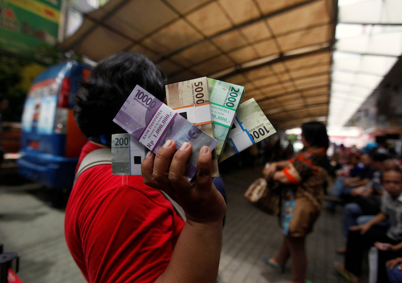 A woman holds newly designed Indonesia rupiah banknotes after exchanging her old bills at a Bank Indonesia mobile bank in Jakarta December 19, 2016. u00e2u20acu201d Reuters pic