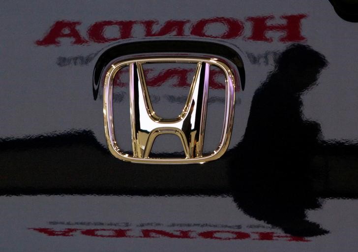 A visitor and the logo of Honda Motor Co are reflected on a Honda car at the companyu00e2u20acu2122s headquarters in Tokyo January 30, 2009. u00e2u20acu201d Reuters picnn