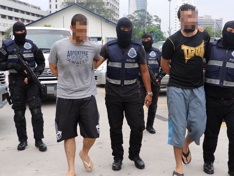 Counter Terrorism personnel detain two of the suspects during nationwide raids recently. u00e2u20acu201d Picture by Royal Malaysian Police