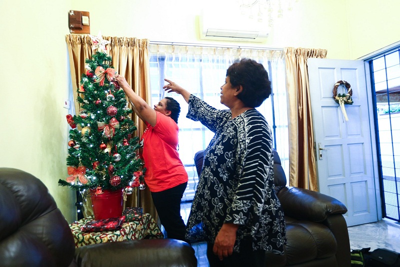 Denise decorates a Christmas tree with help from her mother, Delna Gomez, 60. nu00e2u20acu201d Picture by Ahmad Zamzahurin