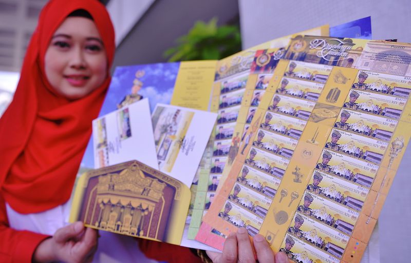Pos Malaysia Berhad officer, Norsazila Zainuddin showing the special stamps of the Yang di-Pertuan Agong after a pre-launch press conference at Pos Malaysia headquarters, Kuala Lumpur, December 6, 2016. u00e2u20acu201d Bernama pic