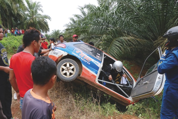 Amirul exits his Proton Satria Neo after it careened into a ditch yesterday. u00e2u20acu201d Picture by Marcus Pheong 