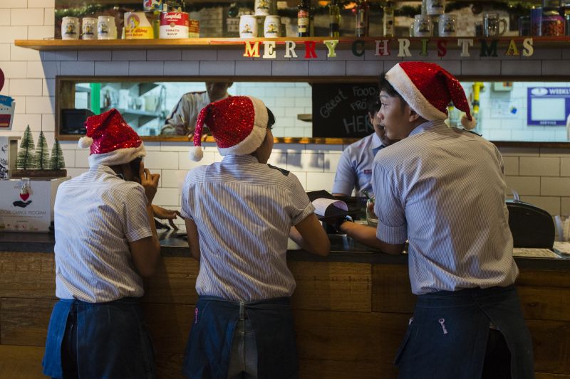 Restaurant workers wearing Santa hats in Jakarta. u00e2u20acu2022 Picture by Ed Wray/The New York Times