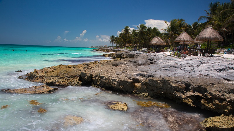 Tourists at shaded tables along a rocky spot on the Yucatan coast in Tulum, Mexico, August 2, 2014. u00e2u20acu201d Picture by David Freid/The New York Times 
