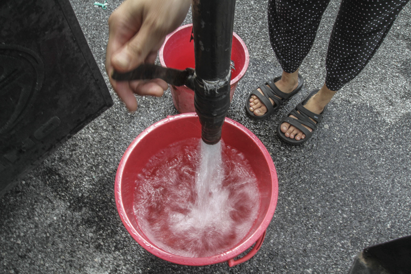 A resident of Bandar Baru Sultan Suleiman collects water from Syabas tank truck in Port Klang December 21, 2016. u00e2u20acu201d Picture by Yusof Mat Isa
