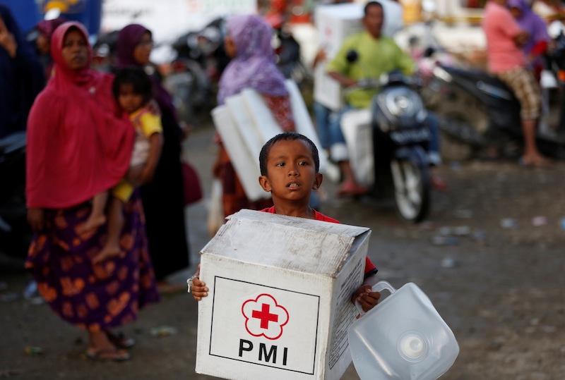A boy carrying an aid package leaves a temporary shelter at a mosque following this week's strong earthquake in Meureudu, Pidie Jaya, Aceh province, Indonesia December 10, 2016. u00e2u20acu201d Reuters pic