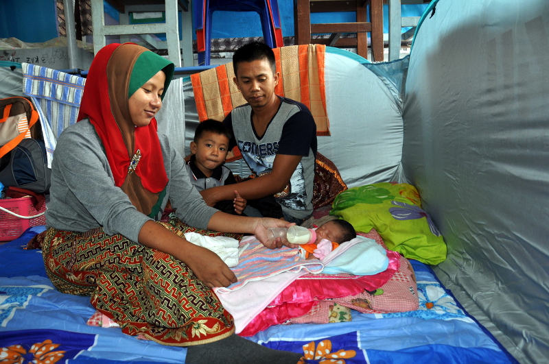Flood victim Suhaili Saharuddin feeds her daughter Nur Sofia Mohd Rizal at the evacuation centre at Sekolah Menengah Kebangsaan (SKM) Badrul Alam Shah in Kemaman December 26, 2016. u00e2u20acu201d Bernama pic