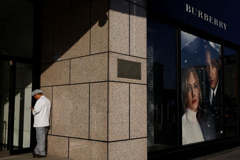 A kitchen staff member stands outside a boutique of the Burberry luxury goods company in Beijing, China, December 1, 2016. u00e2u20acu201d Reuters pic