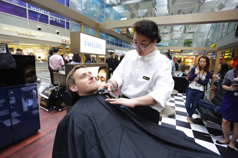 A traveller gets groomed at the Male Grooming Club pop-up barbershop at Changi Airport's Terminal 3 Transit Area. u00e2u20acu201d Picture courtesy of Royal Philips and Lu00e2u20acu2122Oreal Groupe 