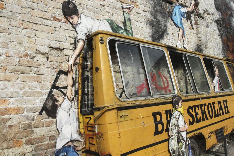 The artwork sports Zacharevic's ‘Zach’ signature in both black and red on the side of the schoolbus and on sliding panels of a window respectively. ― Picture by Yusof Mat Isa