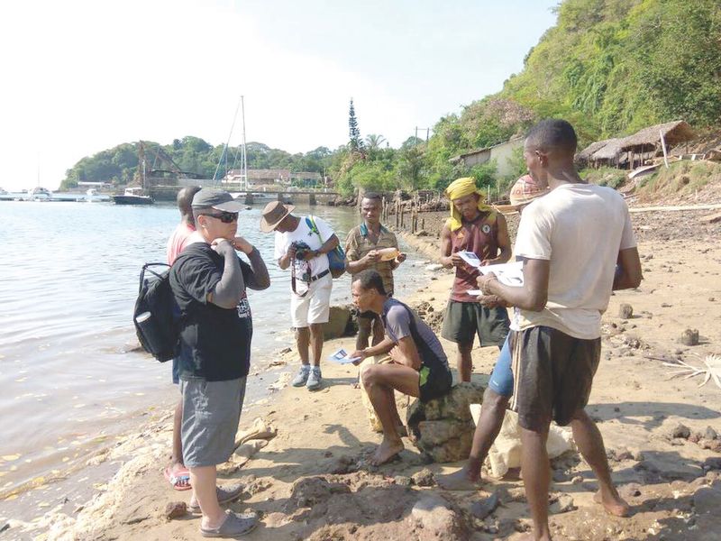 China national Bai Shuan Fu (left) and other next of kin hand out brochures to fishermen near Antsirake in Madagascar. u00e2u20acu2022 Picture courtesy of Grace Nathan