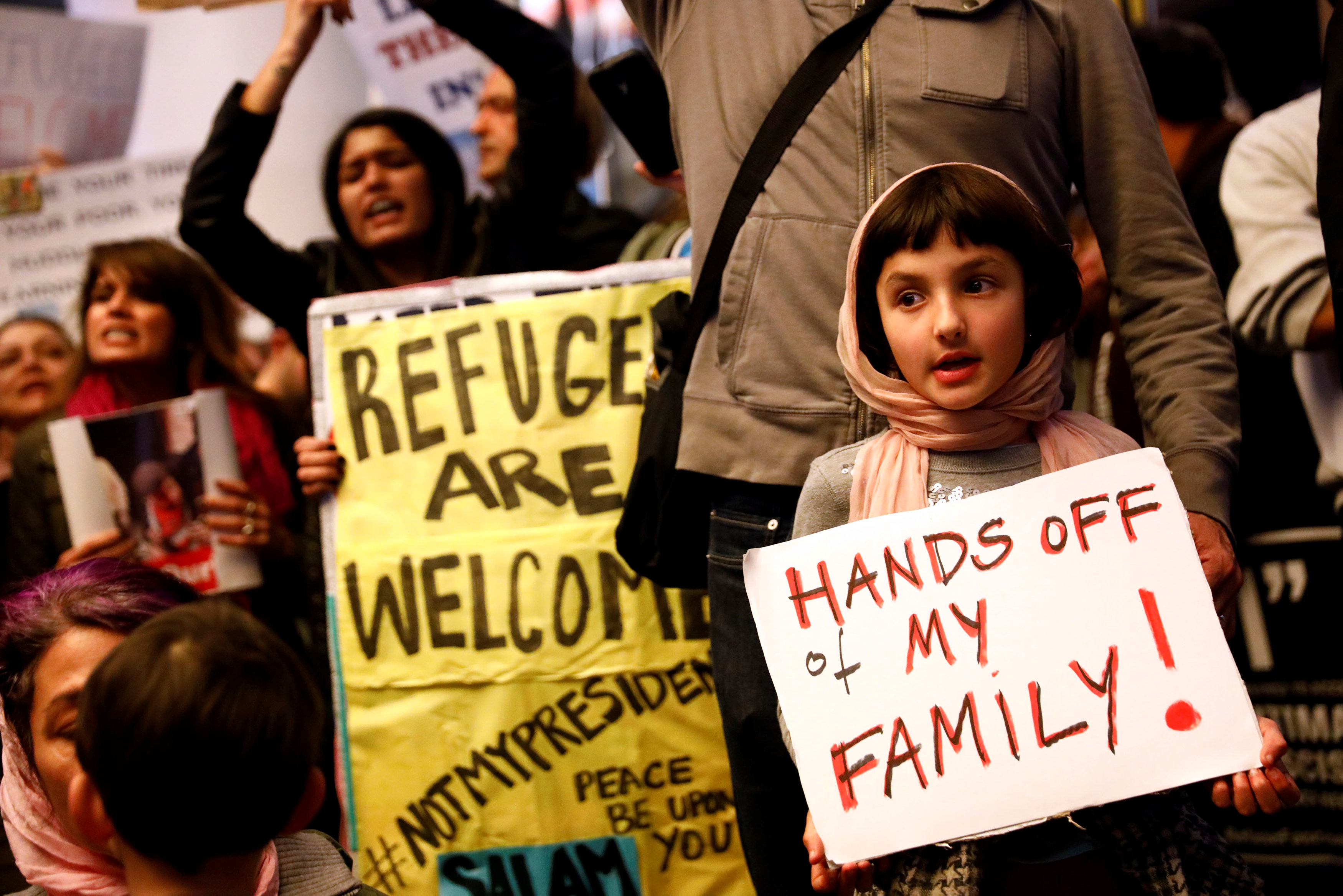 Rosalie Gurna, 9, holds a sign in support of Muslim family members as people protest against U.S. President Donald Trump's travel ban on Muslim majority countries, at the International terminal at Los Angeles International Airport (LAX) in Los Angeles, Ca