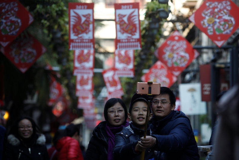 A family takes a selfie in front of decorations placed to celebrate the upcoming Chinese New Year of Rooster at a shopping area in Shanghai January 23, 2017. u00e2u20acu201d Reuters pic