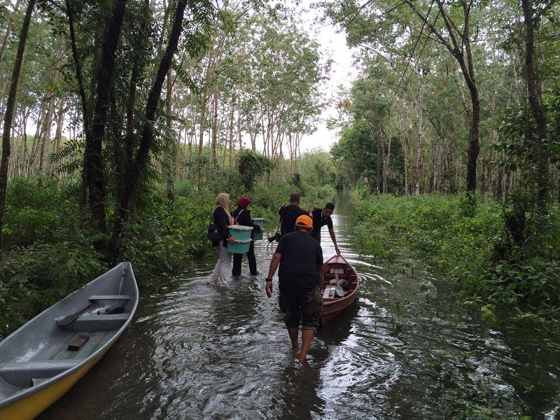 Volunteers from Imaret’s joint mission dragging boats and carrying supplies to reach flood victims in Rantau Panjang.