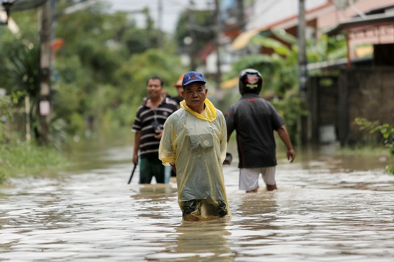 People walk in a flooded street at Muang district in Nakhon Si Thammarat Province, southern Thailand, January 6, 2017. u00e2u20acu201d Reuters pic