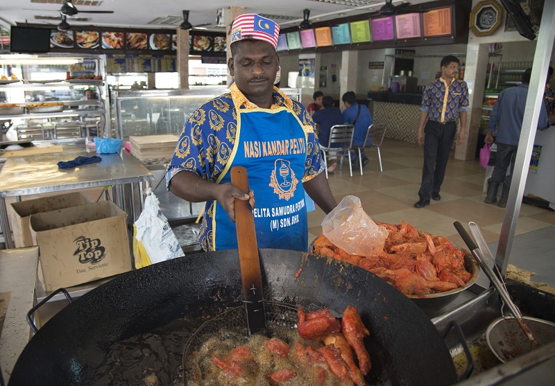 Frying up a batch of spiced crunchy fried chicken at Pelita.