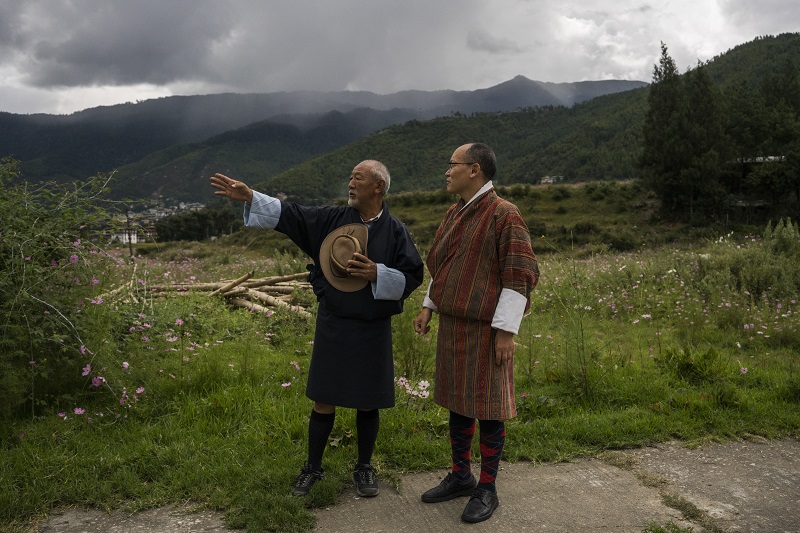 Dasho Karma Ura (right) who has for more than two decades developed Bhutanu00e2u20acu2122s Gross National Happiness indicator, speaks with a resident in Thimphu, September 29, 2016. u00e2u20acu201d Picture by Adam Dean/The New York Times