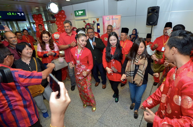 Datuk Seri Idris Haron (kot hitam) menyanyikan lagu Dondang Sayang sambil ditarikan oleh pelancong warga China di KLIA hari ini. u00e2u20acu201d Foto Bernama
