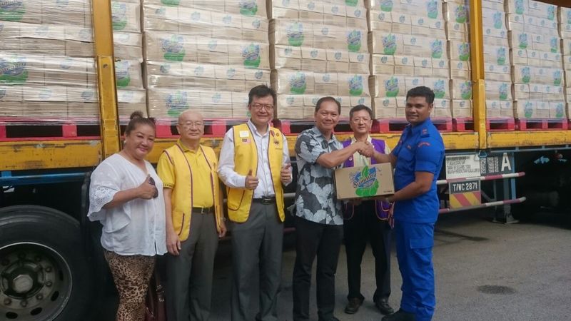 NECF’s Rev Andy Chi handing over aid to a Civil Defence Force officer in front of a trailer-load of bottled drinking water. Others from left to right: Lions Belinda Chow, Phillip Chay, Datuk Ong Theng Soon, Lee Teck Leong. Jan 6, 2017 — Picture courtesy of NECF