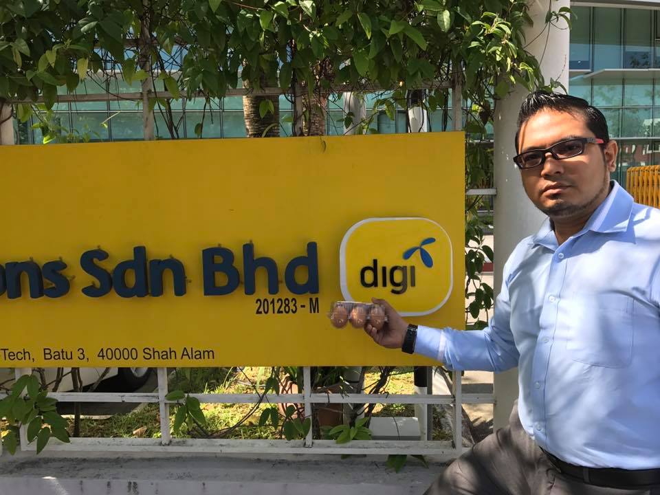 Mohd Al Iman Zakaria pictured standing next to the DIGI sign with a carton of eggs, January 6, 2017. u00e2u20acu201d Photo courtesy of Facebook/Mohd Al Iman Zakaria
