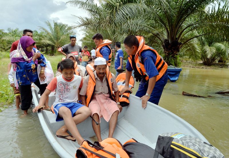 Civil Defence Force personnel evacuating the villagers of Kampung Selat Manggis, Teluk Intan, January 27, 2017, after the main route to the village was closed to traffic due to water levels reaching one to 400 meters. u00e2u20acu201d Bernama pic