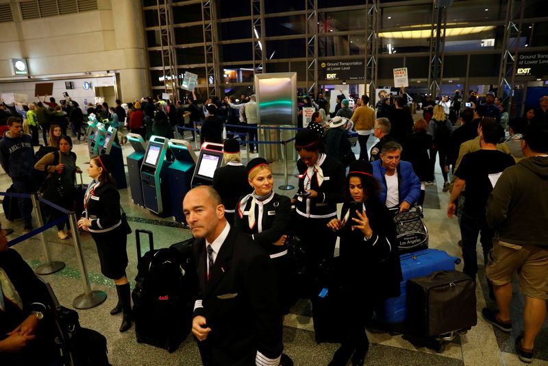 Airline crews watch as people march through the international terminal in protest of Donald Trump's travel ban from Muslim majority countries at Los Angeles International Airport January 28, 2017. u00e2u20acu201d Reuters picn