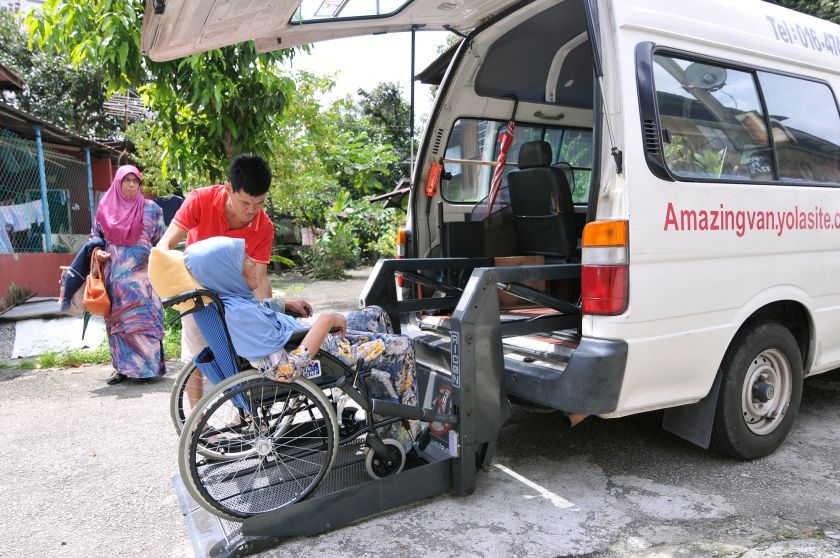 Peter Teoh helping a passenger to get down from the van, January 24, 2017. u00e2u20acu201d Picture by KE Ooi