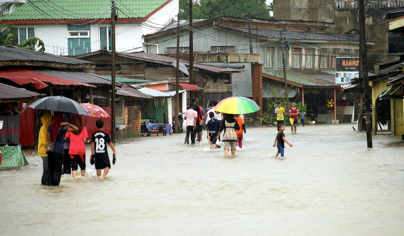Residents wade through the flood in the duty-free zone after incessant rain for a few days in Rantau Panjang January 2, 2017. u00e2u20acu201d Bernama pic