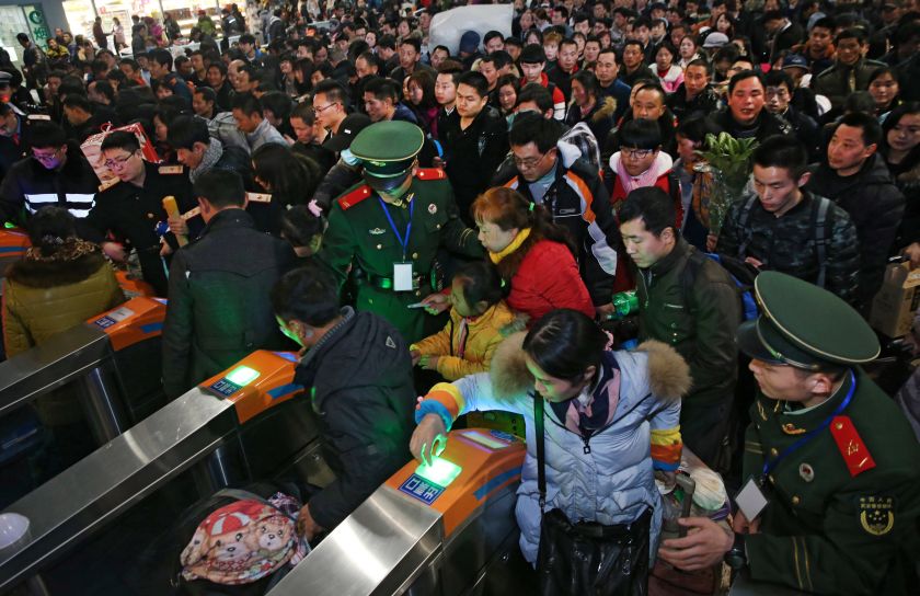 This photo taken on January 23, 2017 shows Chinese paramilitary guards monitoring passengers as they head to their train to travel to their hometowns for the Lunar New Year at Nantong Railway Station in Jiangsu province, near Shanghai. u00e2u20acu201d AFP picnn