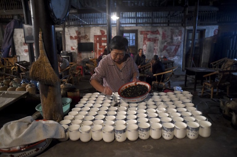 An elderly woman prepares tea for customers at a hundred-year-old teahouse in the early morning in Chengdu, southwest Chinau00e2u20acu2122s Sichuan province, September 11, 2016. u00e2u20acu201d AFP pic