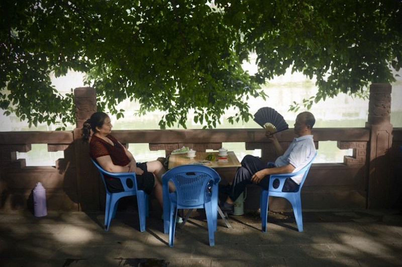 A man chats with a woman at an outdoor teahouse in a park in Chengdu, southwest China’s Sichuan province, September 8, 2016. — AFP pic