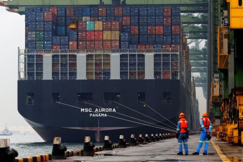 Workers look on as a container ship is unloaded at a berth in a PSA International port terminal in Singapore, September 25, 2013. u00e2u20acu201d Reuters pic