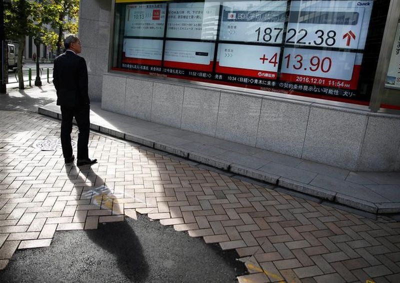 A man looks at an electronic board showing Japan's Nikkei average outside a brokerage in Tokyo December 1, 2016. u00e2u20acu201d Reuters pic