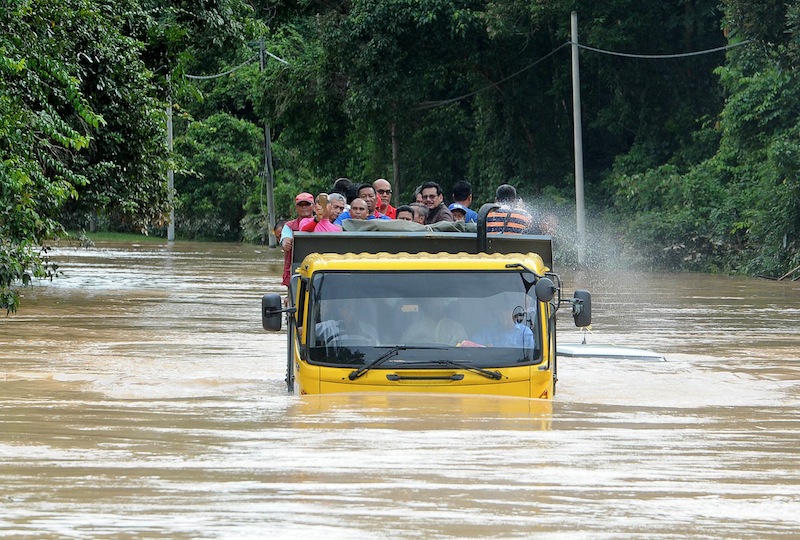 Mangsa banjir menggunakan lori untuk melalui jalan Keruak-Jerteh di Kampung Bekuk, Besut selepas jalan itu ditutup kepada kenderaan ringan setelah ditenggelami banjir, 4 Januari 2016. u00e2u20acu201d Foto Bernama  
