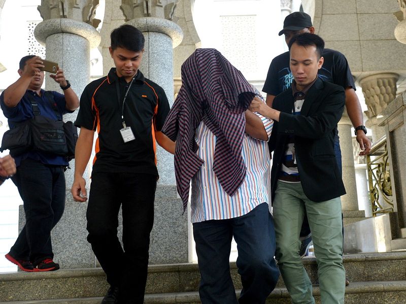 The secretary-general of a ministry (face covered) and his son who were remanded for 11 days to facilitate investigations into alleged corruption and abuse of power, are released on January 15, 2017. u00e2u20acu201d Bernama pic
