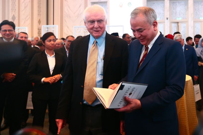 Sultan Nazrin flips through his new book as Professor Dwight Perkins of Harvard University looks on. u00e2u20acu201d Picture by Ahmad Zamzahuri