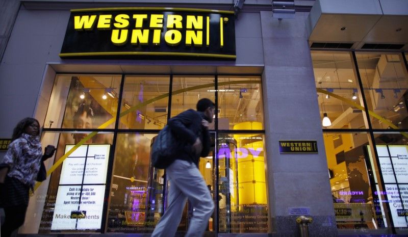 People walk past a Western Union branch at Times Square in New York November 30, 2011. u00e2u20acu201d Reuters pic