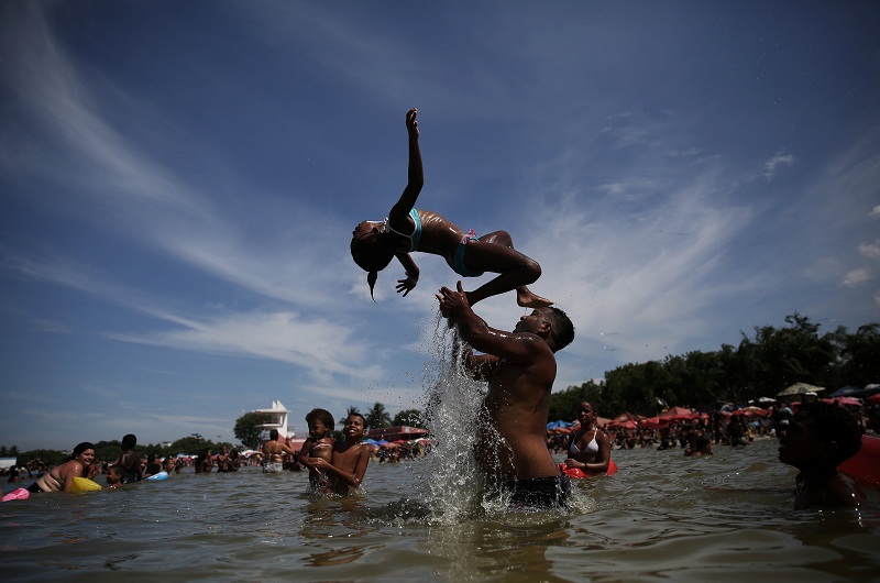 People play at an artificial pond known as piscinao, or big pool, in the northern suburbs of Rio de Janeiro January 8, 2017.
