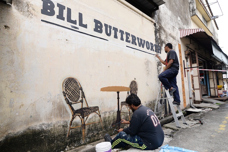 Artists Shazwan Jalil and Syamsul Addeno (left) painting the murals along the art alley. 